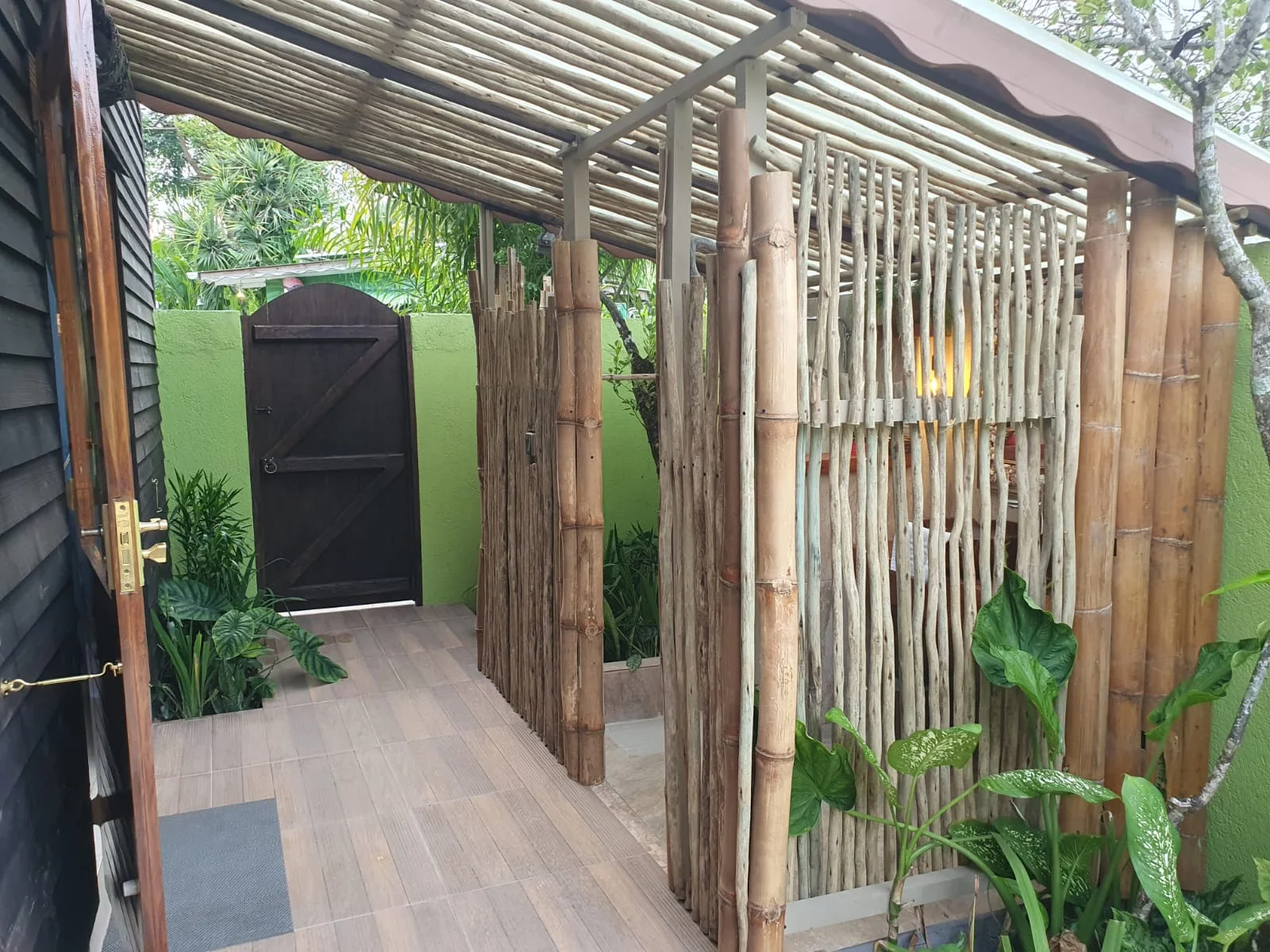 Garden Suite 1 bedroom with king bed, sage green walls and fresh hibiscus on rolled towels — boutique accommodation at Maison Soleil, Anse Soleil, Seychelles