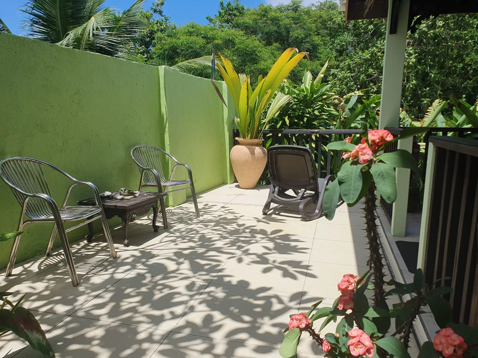 Bright bedroom with turquoise accent wall, wicker armchairs and pendant lighting — Garden Suite 1 at Maison Soleil, Anse Soleil, Seychelles