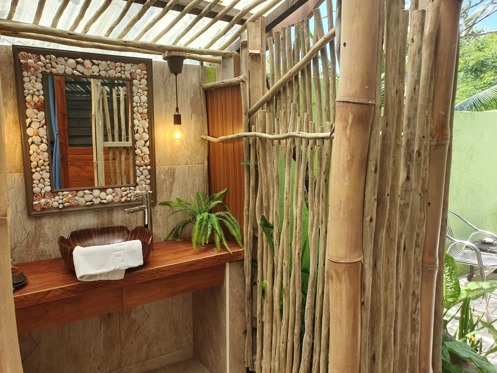 Garden Suite 1 living area with daybed, wooden armchairs and tropical beach artwork — self-catering lounge at Maison Soleil, Anse Soleil, Seychelles