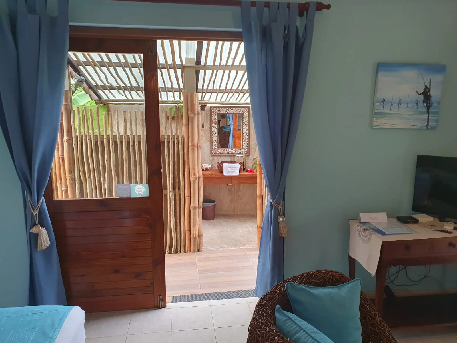 Living area with lime-green daybed and large windows overlooking lush tropical garden foliage — Garden Suite 1 at Maison Soleil, Anse Soleil, Seychelles
