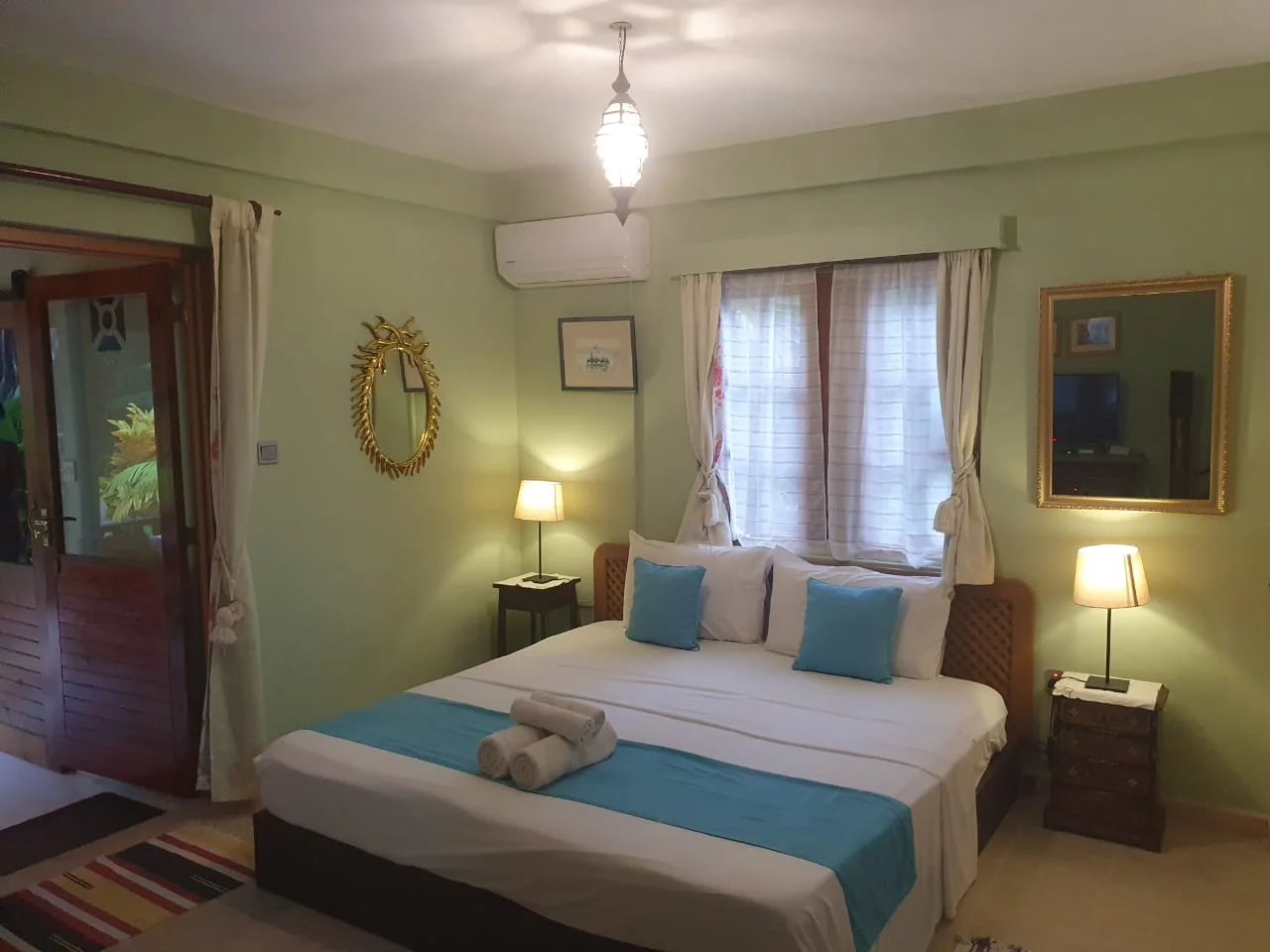 Garden Suite 2 bedroom with king bed, turquoise runner, sage green walls and gold mirrors — boutique accommodation at Maison Soleil, Anse Soleil, Seychelles