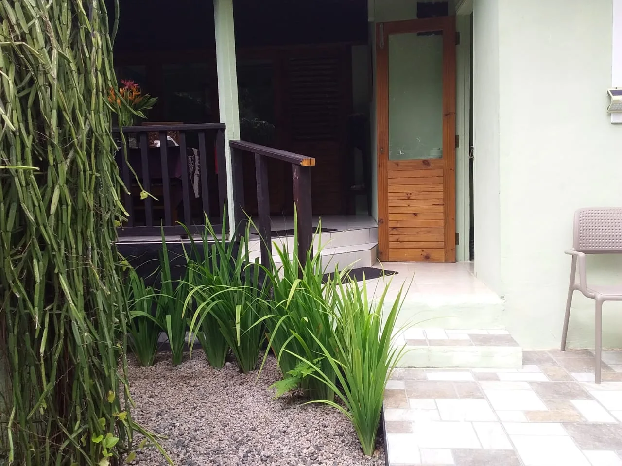 Private garden entrance with wooden door, pebble landscaping and tropical planting — Garden Suite 3 at Maison Soleil at Maison Soleil, Anse Soleil, Seychelles