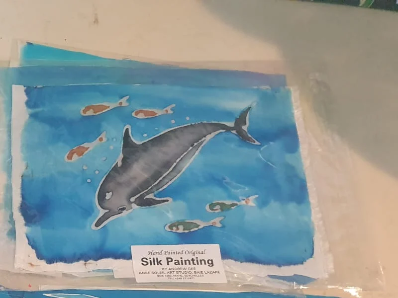 Hand-painted silk painting of a dolphin with tropical fish — original artwork at Anse Soleil Art Studio at Maison Soleil, Anse Soleil, Seychelles (Andrew Gee, Seychelles)